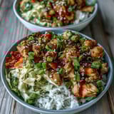 Tender Chicken and Cabbage in a savory bowl, garnished with green onions and sesame seeds, ready to serve.