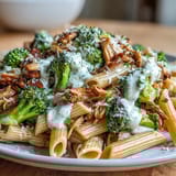 Garlic and lemon-scented High Protein Rotisserie Chicken Broccoli Pasta served warm in a rustic skillet.