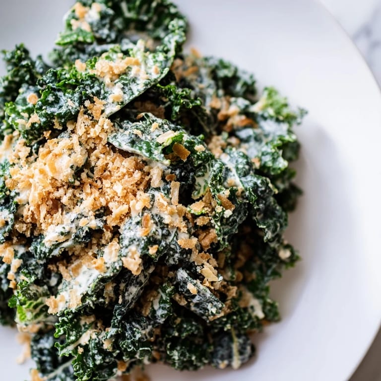 A serving bowl of fresh Garlic Parmesan Kale Salad, highlighting tender kale leaves, shredded Parmesan, and crispy breadcrumbs for a crunchy finish.