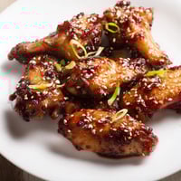 Golden-brown Asian Sticky Wings coated in a glistening, sweet and savory glaze, ready to serve.