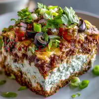 Freshly prepared 4-Way Layered Dip showcases colorful beans, creamy sour cream, and chunky salsa.